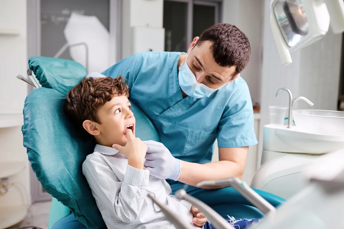 Dental hygienist demonstrating brushing techniques to a child